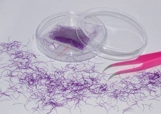 A purple thread and pink scissors on top of a table.