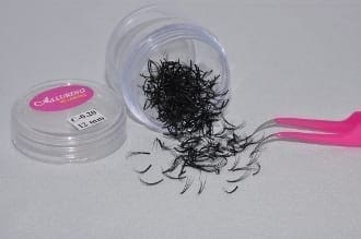 A container of black hair with some pink scissors