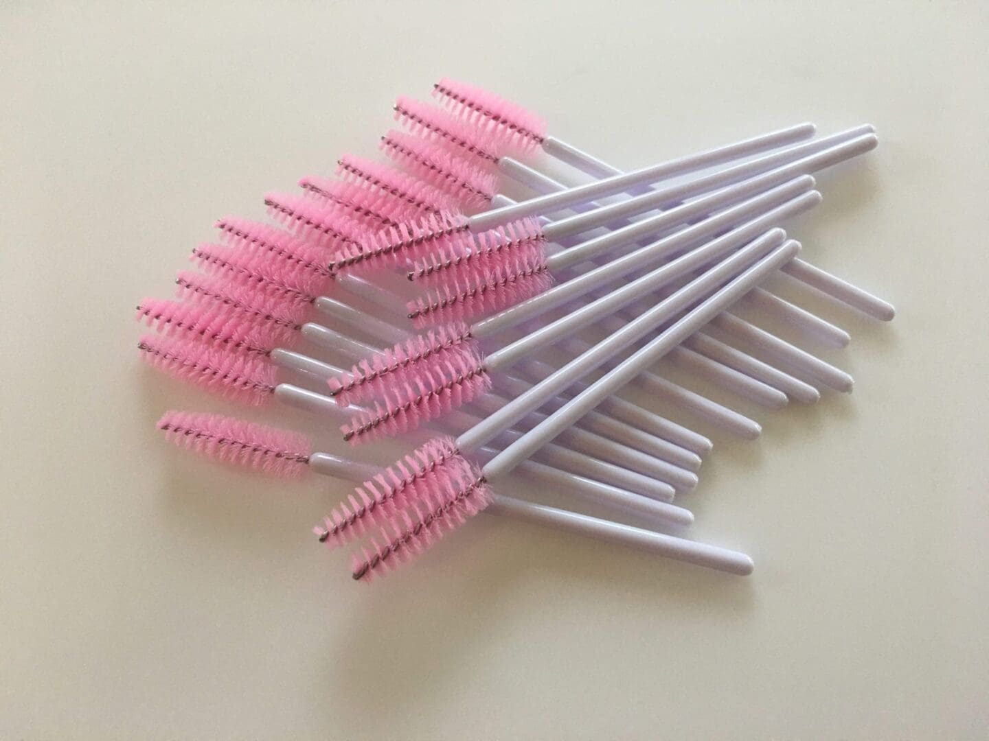 A bunch of pink and white brushes on top of each other.