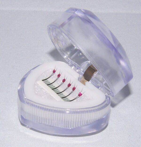 A heart shaped container with a few pieces of toothbrushes inside.