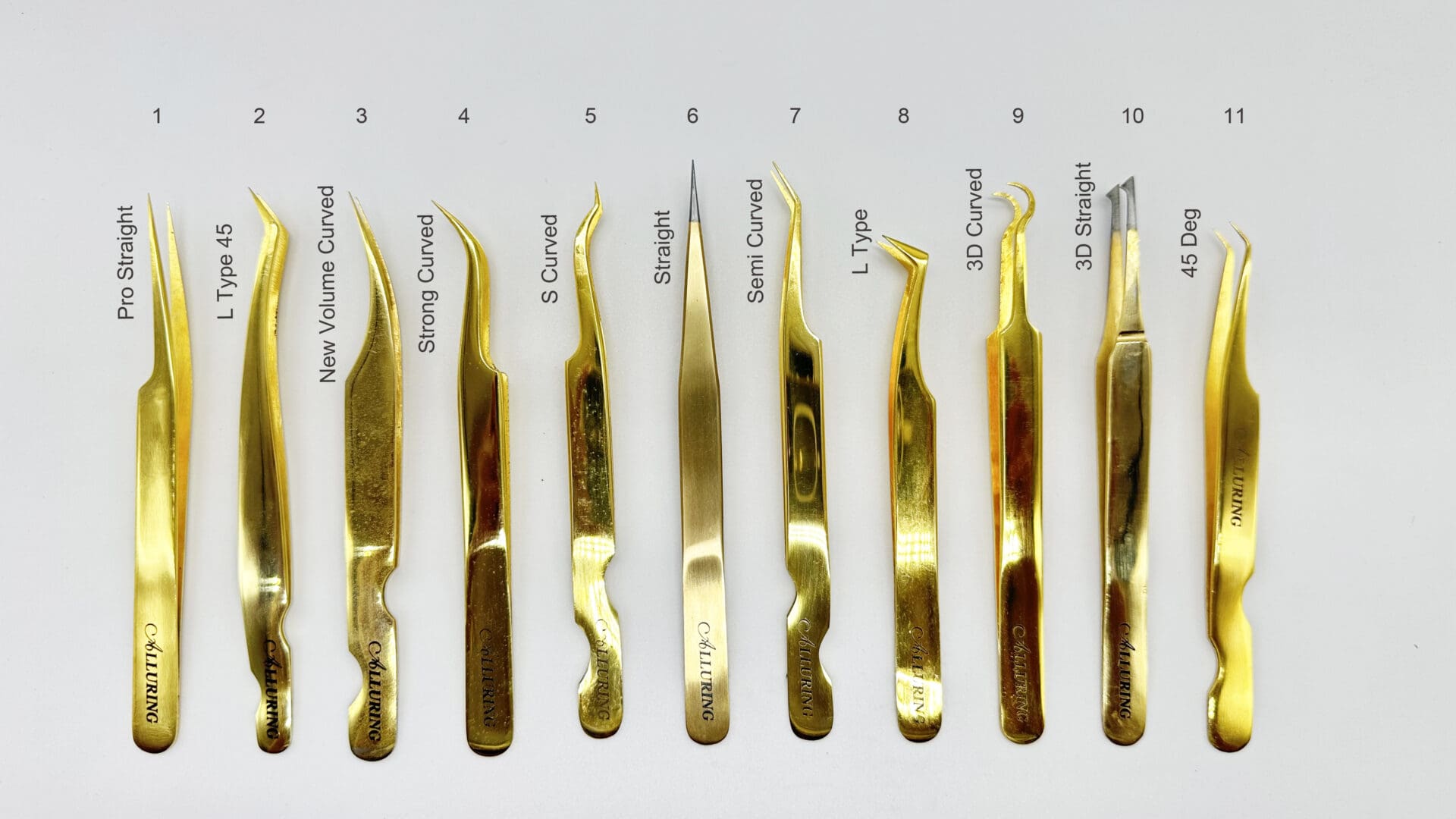 A white table with many different types of gold tweezers.