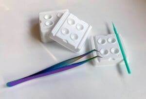 A chrome tweezers with glue wells