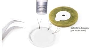 A tweezer, glue, jade stone, and three pieces of eyelash extensions