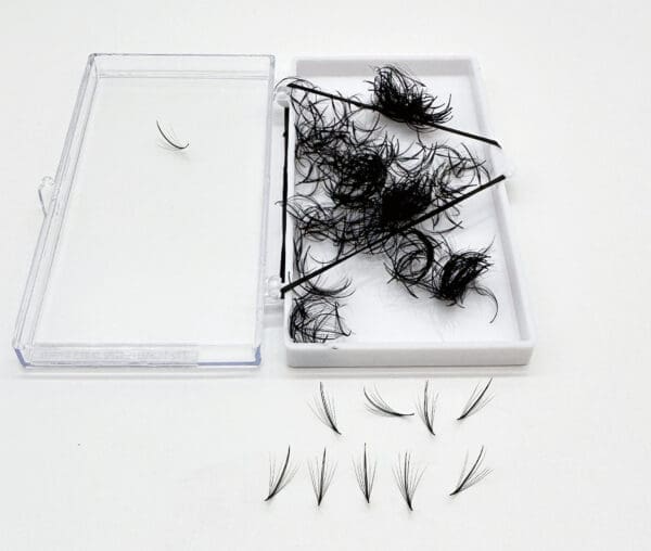 A box of feathers and some scissors on top of the table.